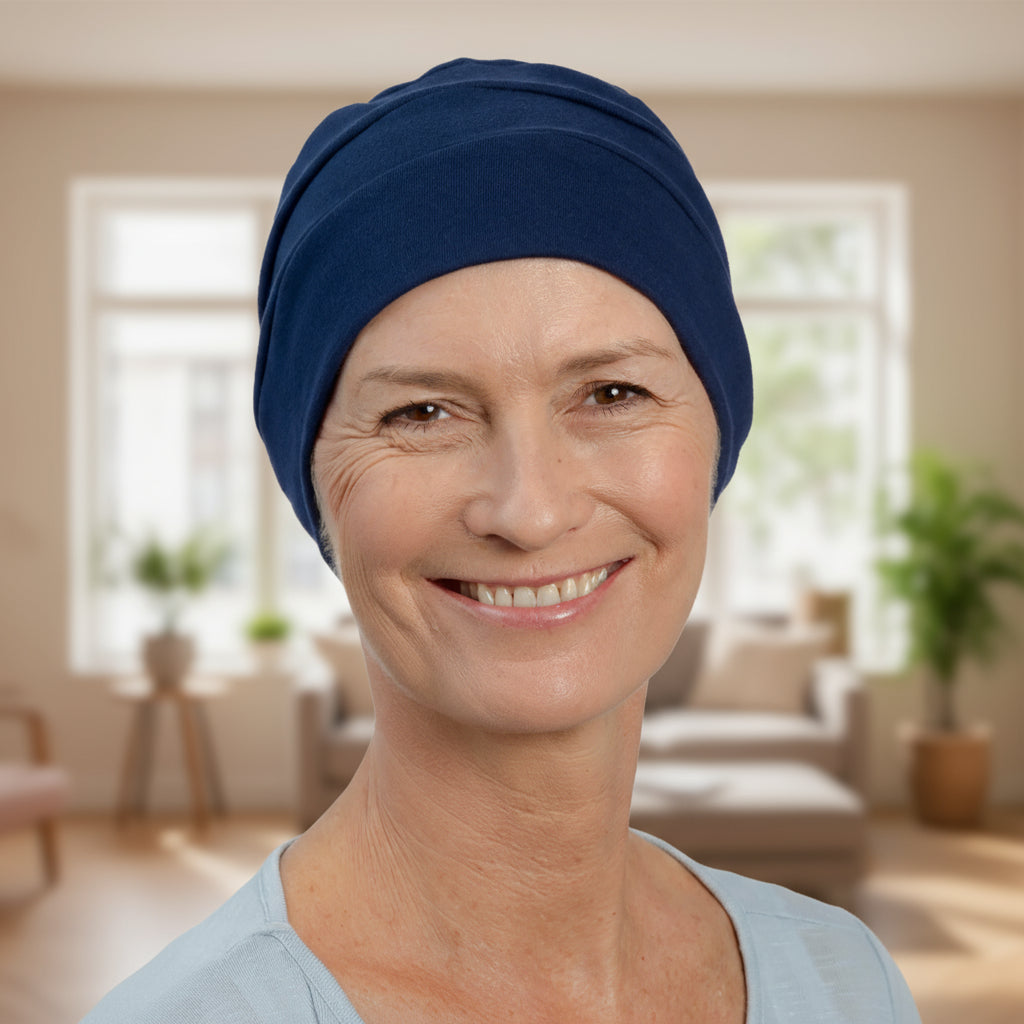 Woman wearing a blue chemo sleep hat in a living room setting
