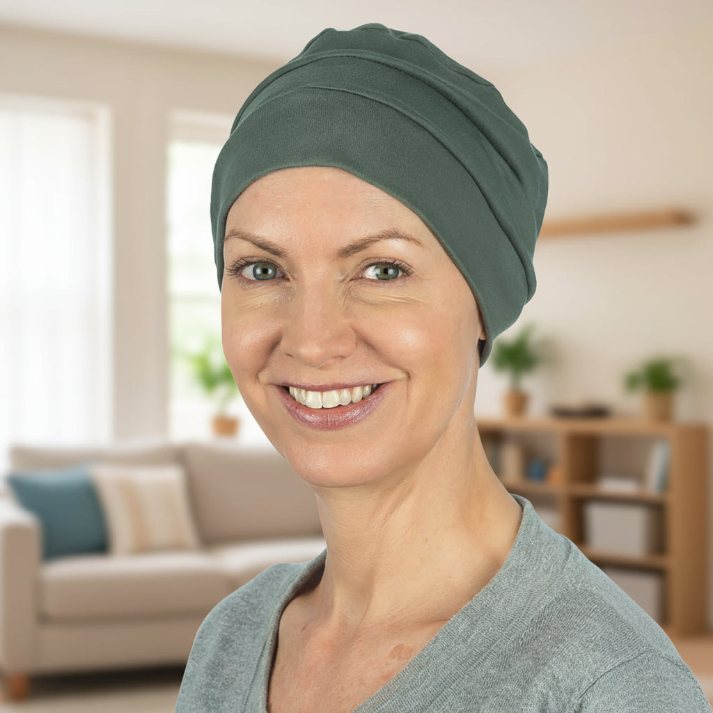 Woman wearing a green chemo hat for hair loss in a living room setting