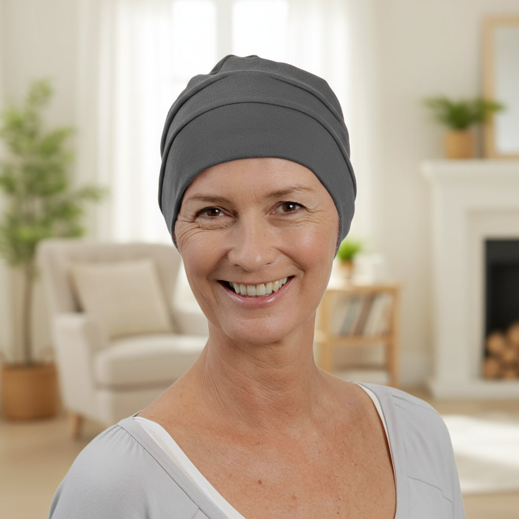 Woman wearing a gray chemo hat in a living room setting