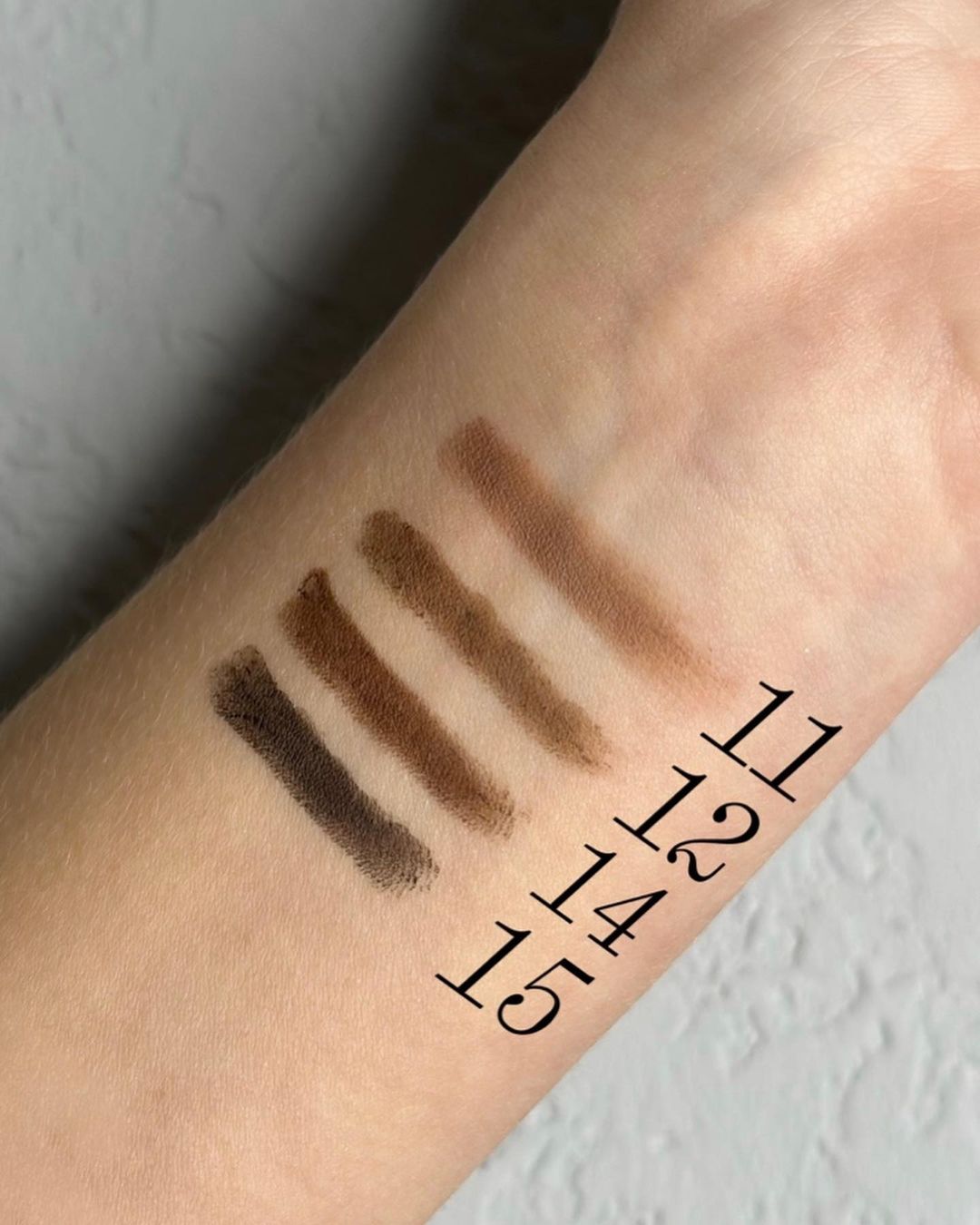 An arm with the four Browmatic eyebrow colours demonstrated