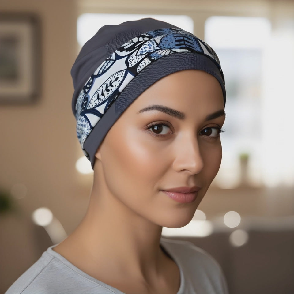 A woman wearing a chemo hat and headband set in blue looking at the camera and smiling